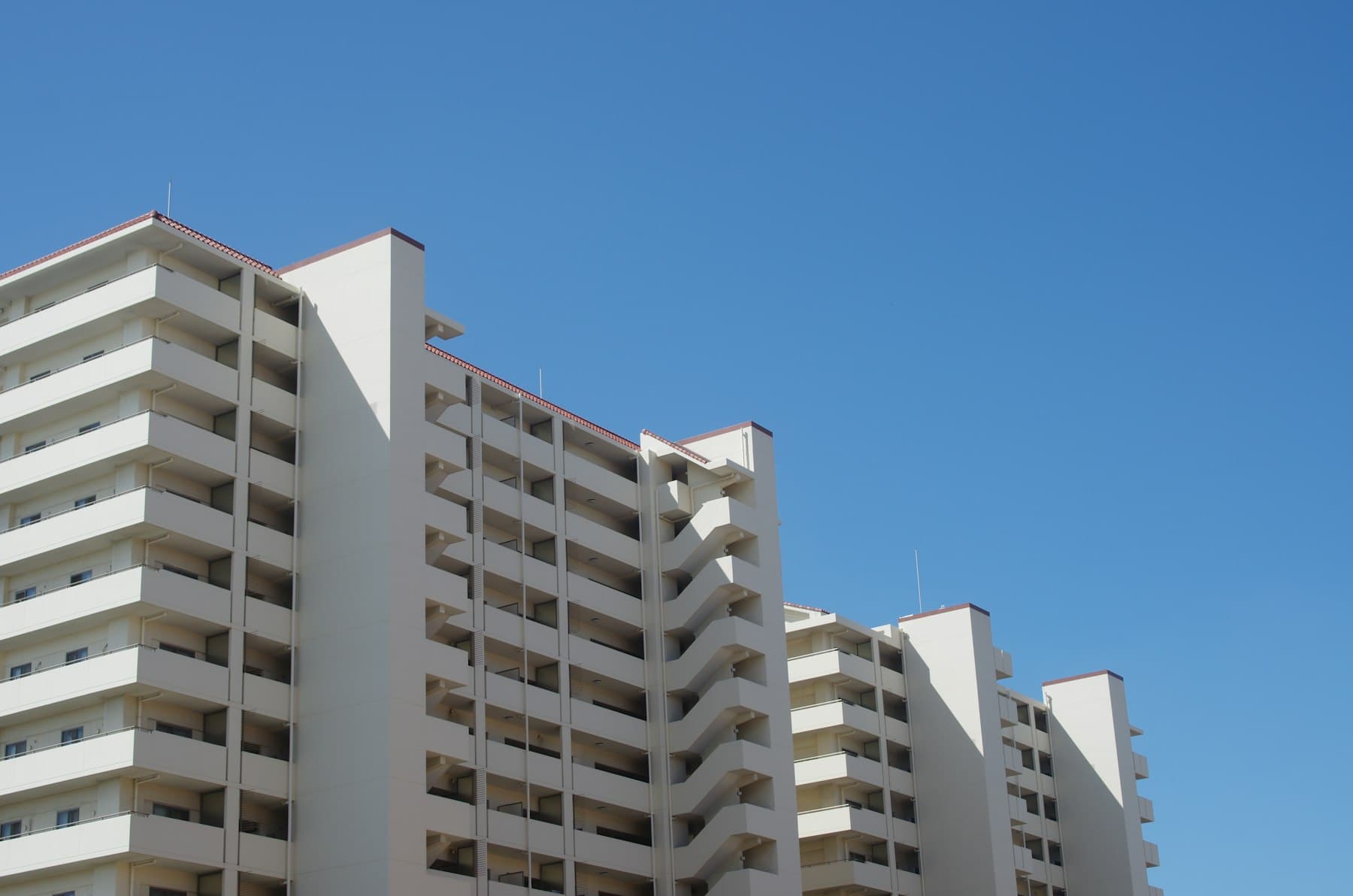 A mid-rise apartment building against a clear sky